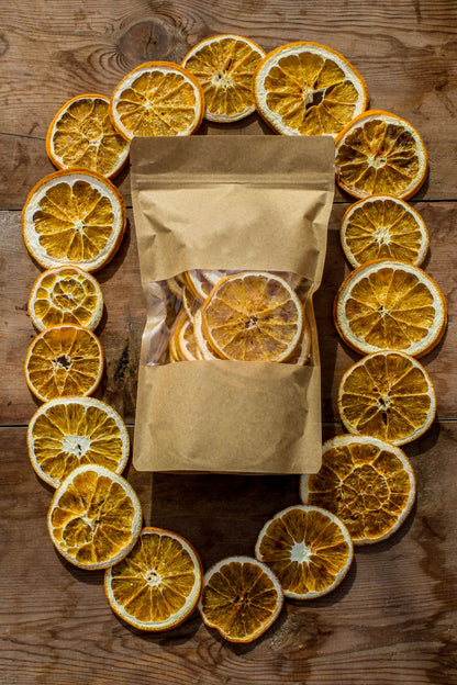 Dried orange slices arranged around a pouch on a wooden table