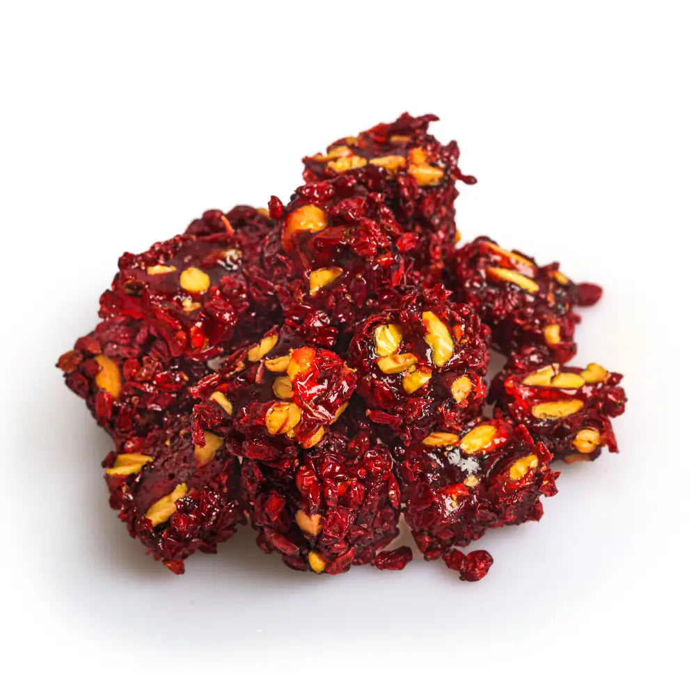 Dark red Turkish Delight pieces with visible pistachios and a red fruit coating